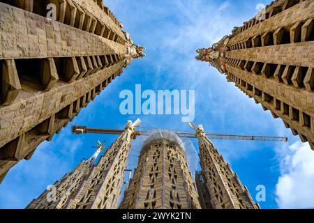 Espagne, Catalogne, Barcelone, quartier de l’Eixample, basilique de la Sagrada Familia par l’architecte moderniste catalan Antoni Gaudi, inscrite au patrimoine mondial de l’UNESCO, deux des quatre campaniles de 135m entourant le ciborium central et la future tour centrale, le pinacle est couronné par le lion ailé qui symbolise Saint Marc et un homme ailé pour Saint Matthieu, au premier plan les pinacles des tours de la façade passion, le sommet récemment achevé de la Tour de Marie avec la lumineuse Maiden Star sur la gauche Banque D'Images