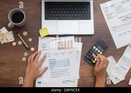 femme gère les finances de la famille, effectue des calculs budgétaires, organise les factures et l'argent sur une table Banque D'Images