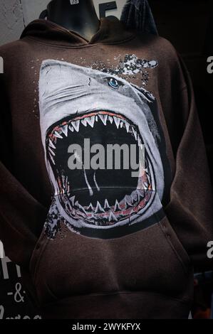 2023 Hampton Beach, New Hampshire. Un mannequin se tient devant une vitrine de promenade, s'habille d'un sweat-shirt marron orné d'un requin blanc. Banque D'Images