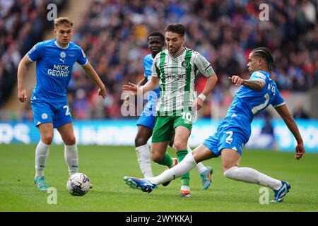 Luke Leahy des Wycombe Wanderers (au centre) et Jadel Katongo de Peterborough United (à droite) s'affrontent pour le ballon lors de la finale du Bristol Street Motors Trophy au stade de Wembley, à Londres. Date de la photo : dimanche 7 avril 2024. Banque D'Images