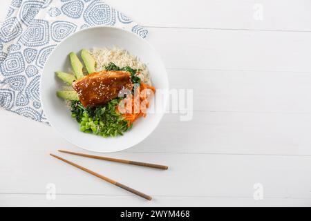 poke bol style asiatique avec saumon et légumes, espace pour la copie et les baguettes Banque D'Images