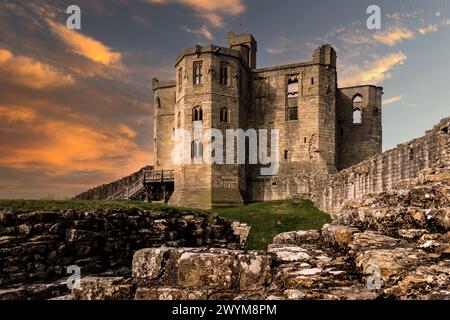 CHÂTEAU DE WARKWORTH, NORTHUMBERLAND, ROYAUME-UNI - 16 MARS 2024. Donjon fortifié en forme de croix du château de Warkworth et ruines avec un ciel spectaculaire au coucher du soleil Banque D'Images