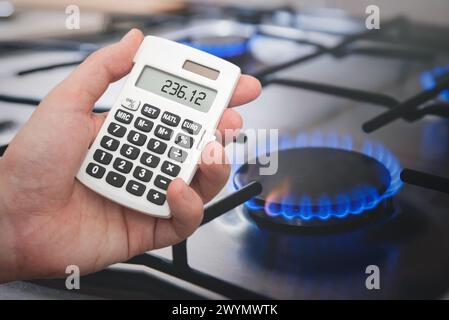 L'homme compte les factures d'essence sur une calculatrice. Augmentation du prix de l'essence Banque D'Images