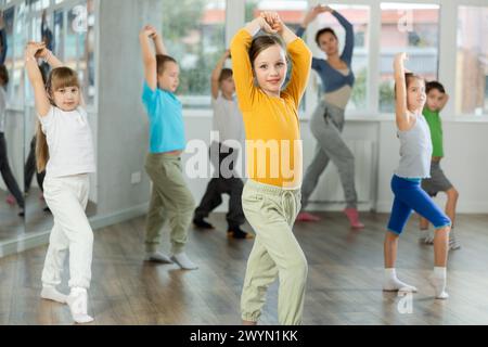 Fille apprendre à danser des danses modernes, faire du mouvement avec un professeur méconnaissable. Banque D'Images