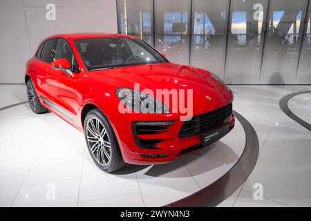 Nouvelle Porsche Macan Turbo rouge, 4x4 transmission intégrale, voiture de sport d'élégance dans le showroom, développement durable, innovation dans l'industrie automobile Porsche Banque D'Images