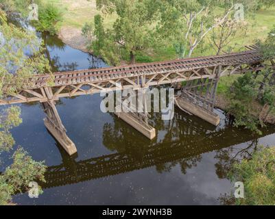 Vue aérienne d'un pont ferroviaire historique sur une rivière calme entourée d'eucalyptus à Gundagai dans les plateaux du sud de la Nouvelle-Galles du Sud Banque D'Images