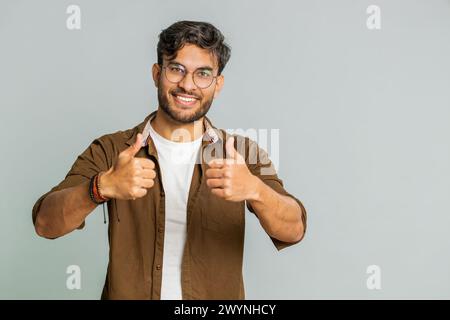J'aime. L'homme indien soulève les pouces vers le haut est d'accord avec quelque chose ou donne une réponse positive recommande la publicité aime la rétroaction de bonne idée, célébrant la victoire de succès. Guy isolé sur fond gris studio Banque D'Images