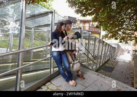 Jeune couple de touristes. Escalator, vieille ville, Vitoria-Gasteiz, Alava, pays Basque, Espagne. Banque D'Images