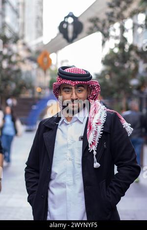 portrait pour jeune homme arabe portant des vêtements traditionnels avec un fond moderne et des lumières floues Banque D'Images