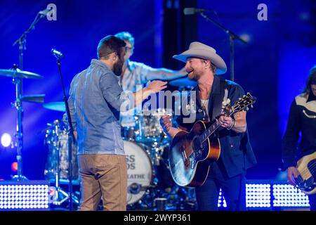 Le groupe de country rock américain NEEDTOBREATHE avec le chanteur BEAR RINEHART (portant un chapeau de cow-boy) fait équipe avec le chanteur country JORDAN DAVIS (en chemise bleue) lors d'un enregistrement de CMT Country Crossroads sur le campus de l'Université du Texas le 5 avril 2024. Crédit : Bob Daemmrich/Alamy Live News Banque D'Images