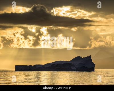 Ciel spectaculaire au-dessus d'un iceberg dans le détroit d'Orléans au large de la côte Davis de la péninsule Antarctique. Banque D'Images