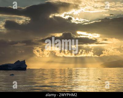 Ciel spectaculaire au-dessus d'un iceberg dans le détroit d'Orléans au large de la côte Davis de la péninsule Antarctique. Banque D'Images