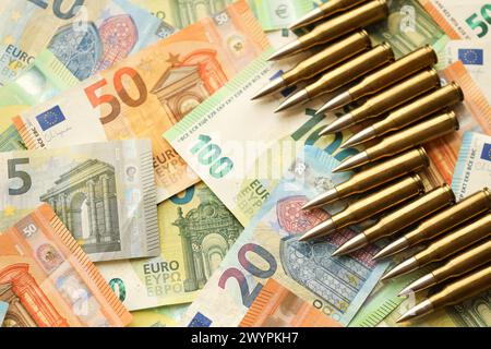 Cartouches et enveloppes jaunes sur les billets en euros. Beaucoup de billets de la monnaie de l'union européenne et des munitions en gros plan Banque D'Images