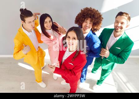 Portrait d'un groupe de jeunes joyeux, élégants et à la mode vêtus de costumes colorés. Banque D'Images