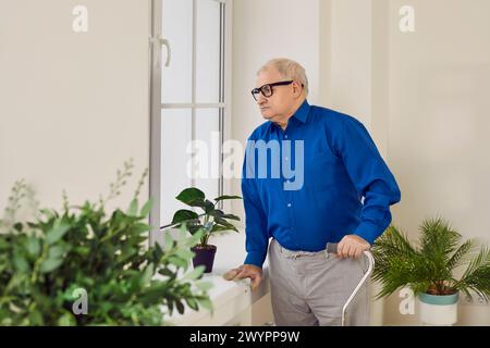 Portrait d'homme senior réfléchi regardant par la fenêtre Banque D'Images