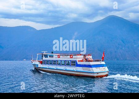 GANDRIA, SUISSE - 17 MARS 2022 : le bateau touristique navigue le long du lac de Lugano depuis le village de Gandria, le 17 mars à Gandria, Suisse Banque D'Images