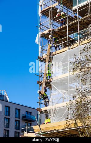 Des ouvriers de la construction travaillent ensemble sur le site de développement des jardins Mirabelle, rue Penny Brooks, Stratford East Village, Londres, Angleterre Banque D'Images