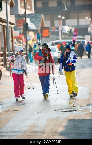 Trois skieurs marchant dans la rue dans le village italien Champoluc en Italie. Banque D'Images