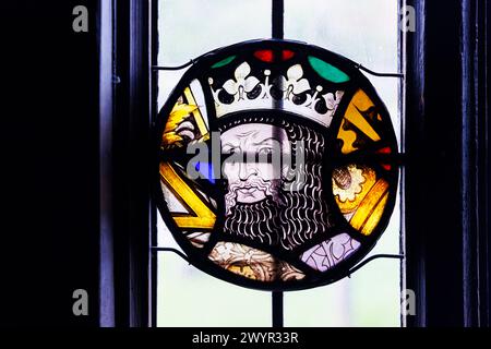 Vitrail à fenêtre lumineuse au plomb portrait d'un roi couronné dans la maille à chaîne dans le pub Crown à Chiddingfold, un village du Surrey, au sud-est de l'Angleterre Banque D'Images