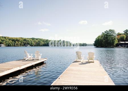 Tranquillité au bord du lac avec chaises Adirondack sur le quai Banque D'Images