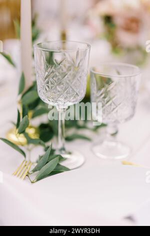 Verrerie en cristal élégante et couverts dorés sur la table Banque D'Images