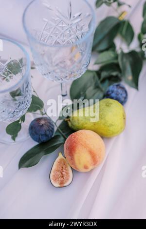 Décoration de fruits frais et verres en cristal sur une table élégante Banque D'Images