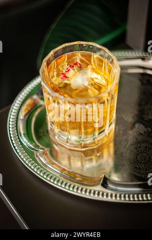 Whisky en verre de cristal avec des glaçons sur un plateau en argent Banque D'Images