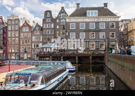 Restaurant Grasshopper, maisons de canal et bateaux d'excursion au Damrak dans le centre d'Amsterdam. Banque D'Images
