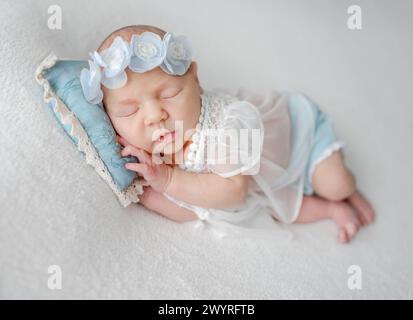 Fille nouveau-née en dentelle Robe dort dans les tons blancs et bleus photo Banque D'Images