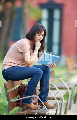 35 femme avec tablette dans un parc. Donostia. San Sebastian. Gipuzkoa. Pays Basque- Espagne. Banque D'Images