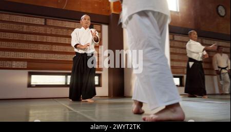 Étudiants japonais, aikido ou sensei en dojo pour commencer à pratiquer la leçon, la discipline ou l'enseignement de l'autodéfense. Maître ceinture noire, les gens apprennent le combat Banque D'Images