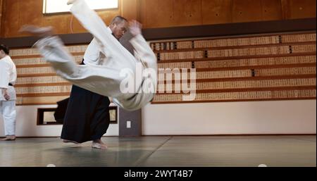 Étudiants japonais, jetez ou sensei dans le dojo pour commencer la leçon de pratique, la discipline ou l'enseignement de l'autodéfense. Maître ceinture noire, les gens apprenant le combat ou Banque D'Images