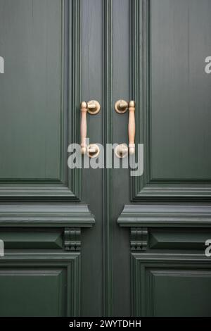 Poignées de porte dorées sur portes en bois vertes. Prise de vue verticale Banque D'Images
