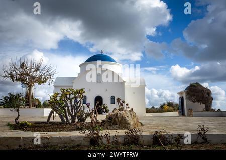 Paphos, Chypre - 23 décembre 2023 : petite adorable église Saint Nicolas blanche et bleue sur la côte de la mer. Banque D'Images