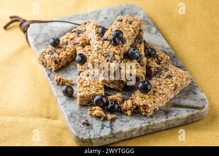 Diverses barres de granola sur fond de table. Barres granola de céréales. Barres de petit-déjeuner superfood avec avoine, noix et baies, gros plan. Banque D'Images