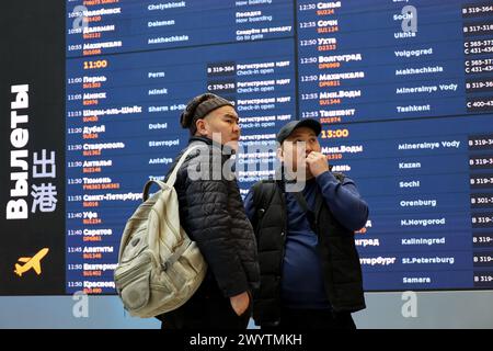 Passagers regardant le tableau de départ dans le terminal B de l'aéroport Sheremetyevo à Moscou Banque D'Images