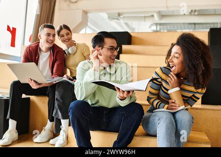 Un groupe multiculturel d'étudiants s'assoit sur les escaliers urbains, prenant une pause des études et appréciant les uns les autres en compagnie. Banque D'Images