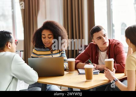 Un groupe multiculturel d’étudiants s’engagent dans une discussion animée autour d’une table en bois, mettant en valeur la diversité et la collaboration. Banque D'Images