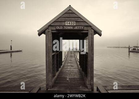 Une image monochrome/sépia de la jetée de la vieille ville par un matin brumeux sur la rivière Blackwood à Augusta, au sud-ouest de l'Australie occidentale. Banque D'Images