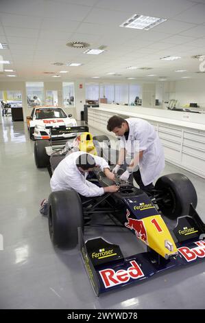 Mécaniciens travaillant sur les voitures de course, les World Series, la formule 3000. Epsilon Euskadi, centre de haute performance technique automobile, Azkoitia, Gipuzkoa, pays Basque. Banque D'Images