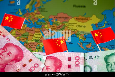 Un concept chinois d'investissements mondiaux dans le sud avec des billets de banque en yuan chinois et des drapeaux nationaux sur une carte de certains pays de l'hémisphère sud. Banque D'Images