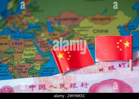 Un concept chinois d'investissements mondiaux dans le sud avec des billets de banque en yuan chinois et des drapeaux nationaux sur une carte de certains pays de l'hémisphère sud. Banque D'Images