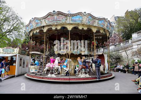 Paris, France - 12 août 2018 : Photographe utilisant Carousel merry-go-round ride avec les chevaux au galop de photographier un modèle à Montmartre Banque D'Images