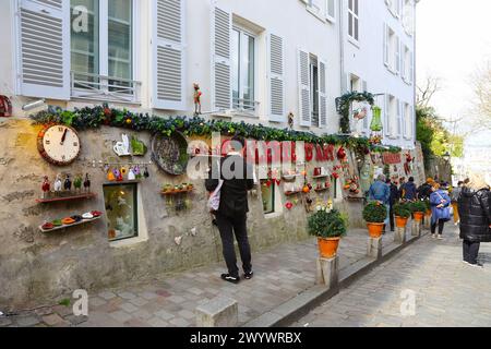 Paris, France -31 mars 2024 : vue sur un café typiquement parisien, fenêtres avec volets bleus, fleurs, rues, galeries avec expositions, touristes et Banque D'Images