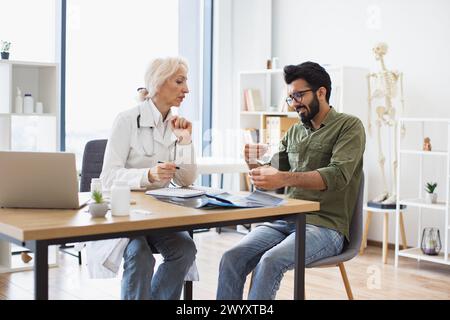 Le médecin aîné mûr donne des recommandations concernant le traitement. Banque D'Images