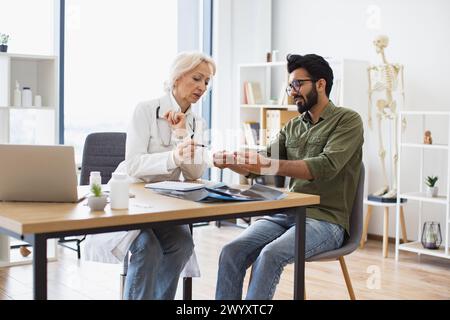 Le médecin aîné mûr donne des recommandations concernant le traitement. Banque D'Images