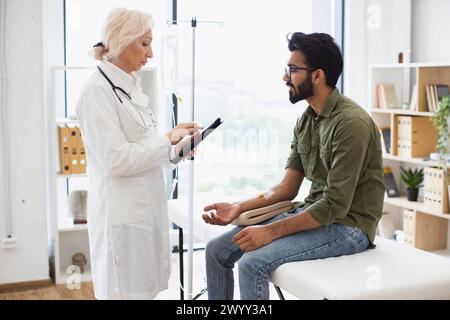 Homme barbu recevant une chimiothérapie regardant une infirmière avec comprimé. Banque D'Images