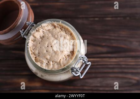 Levain de levain dans un pot en verre sur une table en bois, vue de dessus. Espace pour le texte Banque D'Images