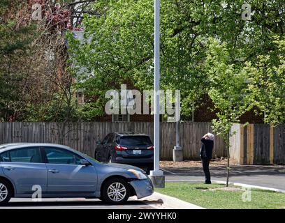 Owensboro, Kentucky, États-Unis. 08 avril 2024. Une femme regarde depuis le parking de la bibliothèque publique du comté de Daviess alors que la lune bouge pour obscurcir le soleil pendant une éclipse solaire totale. Comme visible depuis Owensboro, le soleil était couvert à 99,89% par la lune lorsque l'éclipse a culminé à 14h04 HAC (GMT -5). (Crédit : Billy Suratt/Apex MediaWire via Alamy Live News) Banque D'Images