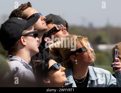 Indianapolis (États-Unis d'Amérique). 08 avril 2024. Indianapolis (États-Unis d'Amérique). 08 avril 2024. Les spectateurs portant des lunettes de protection regardent vers le soleil lors d'un événement total d'observation d'éclipse solaire à l'Indianapolis Motor Speedway, le 8 avril 2024, à Indianapolis, Indiana. Une éclipse solaire totale a balayé une partie étroite du continent nord-américain, du Mexique à la côte atlantique de Terre-Neuve, au Canada. Crédit : Joel Kowsky/NASA/Alamy Live News Banque D'Images